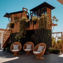 the outside of a house with several round chairs, one for each chair and one for the opposite seat