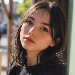 a woman is staring straight ahead while sitting on the street