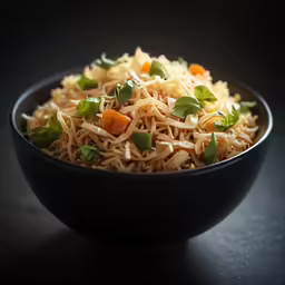 a bowl with noodles and carrots is sitting on a table