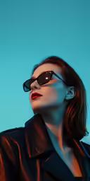 a woman wearing black is standing against a blue sky