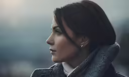 a woman wearing earrings and looking over her shoulder