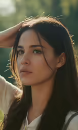 a beautiful young woman standing in front of a forest