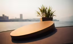 a wooden plate sitting on top of a table near water