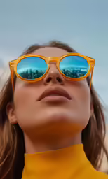 a woman wearing sunglasses is looking at the sky