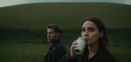 a man and woman drinking coffee standing in a field