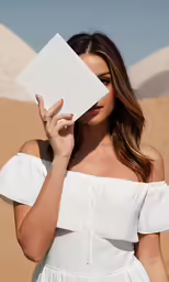a woman covering her eyes and covering her face with an envelope