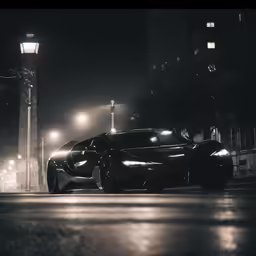 a black sport car parked at night next to street lamps