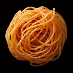 some noodles are sitting in the dark with a black background