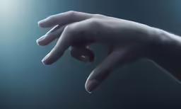 a hand reaching out to touch something off white