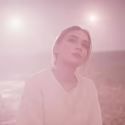 a woman is standing alone near the ocean