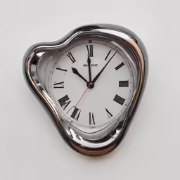 a metal heart - shaped clock has two tone dial