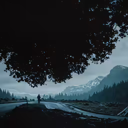 an empty road under a mountain is shown,a man is walking down the road in front of some mountains