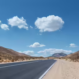 a highway with hills and a sky background