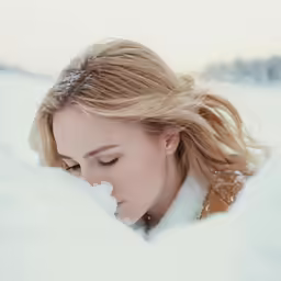 a young blonde haired woman looking out over a deep white field