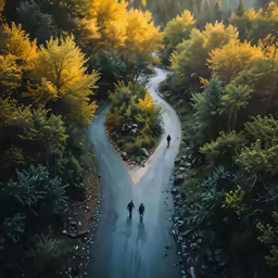two people walk through the road in between two hills