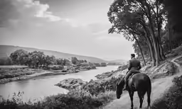a black and white photograph of a woman on a horse