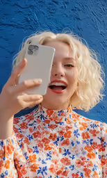 a person holding a phone and showing their tongue