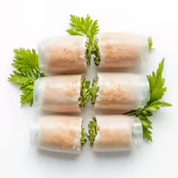 a group of four rolls of food that have greens on top