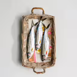 five fish are on top of a breaded basket,three small striped fish sitting in a basket