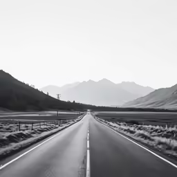 a long road going through an area with mountains in the background
