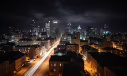 a nighttime view of city lights, skyscrapers, and street traffic