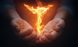 a person holding out their hands over a flame that appears to be a cross