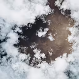 clouds float in the air over a dirt field