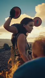 a woman juggling a disk over a fire