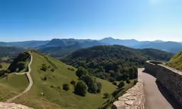 the road is leading to a beautiful view on a hill