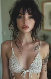 a woman with tattoos wearing a bra in a living room,an image of a woman wearing lingerie and showing her tattoos