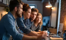 group of people sitting on table looking at laptops