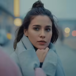 a woman standing on the street looking at something