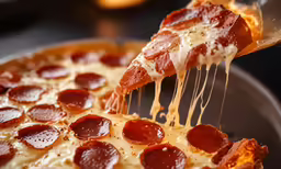 a pepperoni pizza being served on a pan
