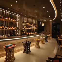 a bar has a counter with many bottles