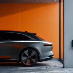 a grey and orange car parked in front of an orange wall