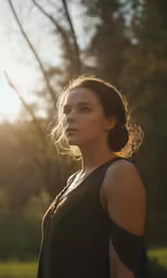 a woman standing in a park looking towards the sky