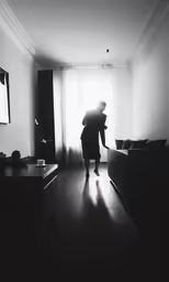 woman in black and white standing on a hard wood floor