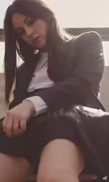a woman sitting in a chair wearing a jacket and shorts