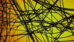 a close up of the top of a power pole,electrical poles in silhouette against a yellow sky