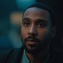 a close up of a person wearing a suit and tie