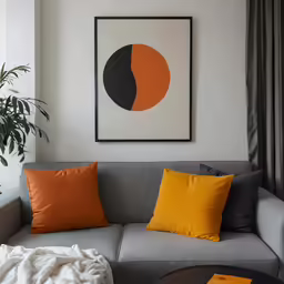 a living room with grey couch and a yellow throw blanket