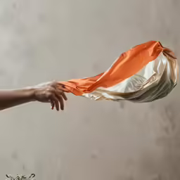 a person that is pulling up an orange cloth