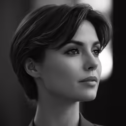 the woman is wearing a tie and has a very short hair