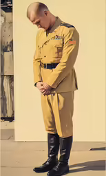 a man wearing uniform stands on concrete