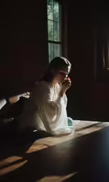 a girl is sitting and playing with the sunlight