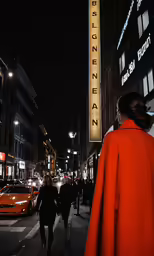 people walk down a city street next to tall buildings
