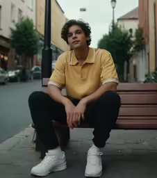 a man sitting on top of a bench next to a light pole