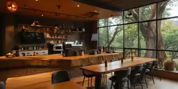 tables and stools sit in front of the window, with shelves on one wall