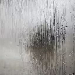 a close up view of rain coming down on a wet river