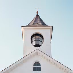 a church with a round window and a large white tower